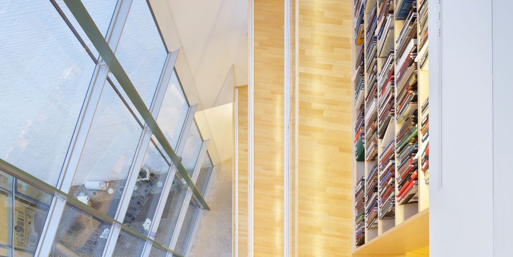 Glasfront und Bücherregal in einem modernen Gebäude.