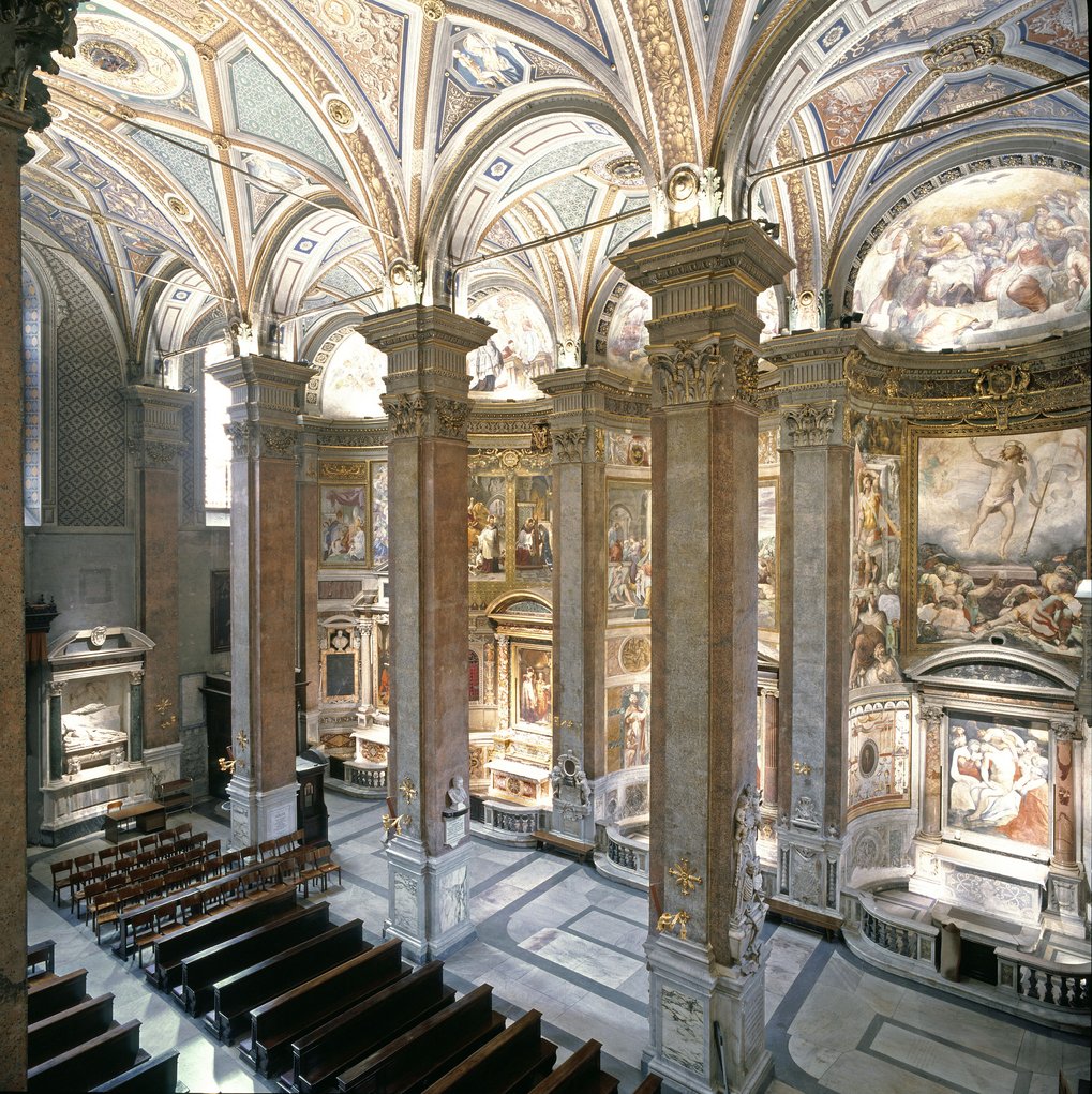 Church interior showcasing intricate frescoes, towering columns, and wooden pews.