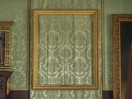 Leerer Bilderrahmen neben Gemälde und Holzverkleidung.