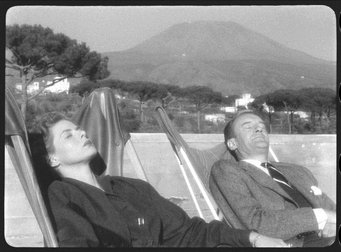 Still frame from Viaggio in Italia (Roberto Rossellini, 1954) Two people relax in deck chairs with a mountain in the background.
